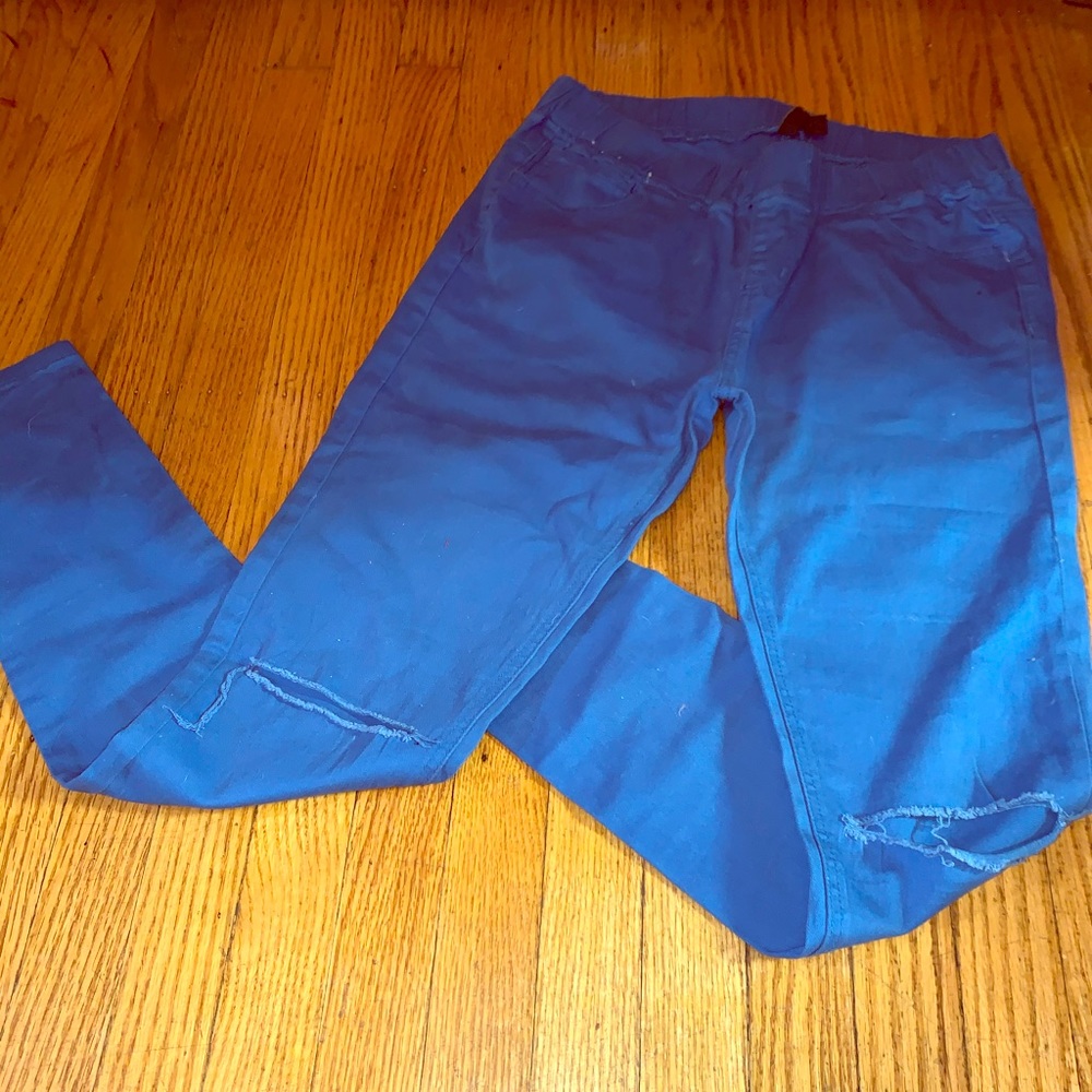 Blue jeggings with ripped/shredded knee opening